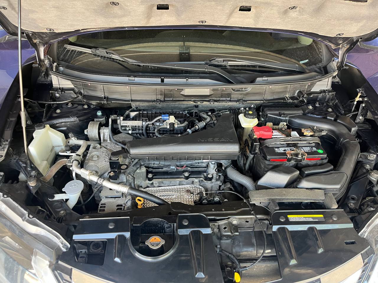 The same engine bay after degreasing and dressing, the plastics and battery tray clean and the bare metal brightened