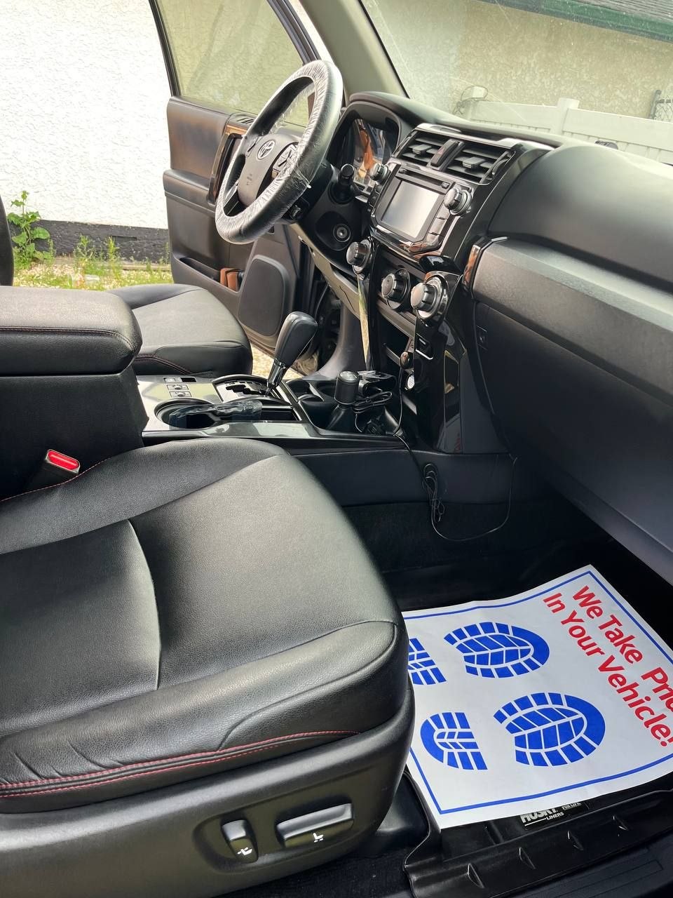 The same 4Runner passenger side after cleaning, the liner and sill clear, a protective paper mat laid down and a cover on the steering wheel
