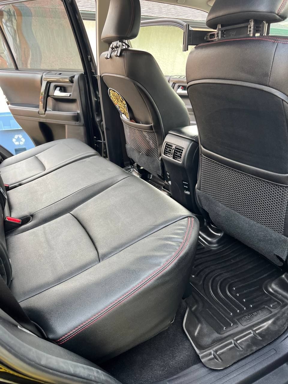 The same 4Runner rear after cleaning, photographed wide enough to show both the leather bench and the rubber footwell liner clear of debris
