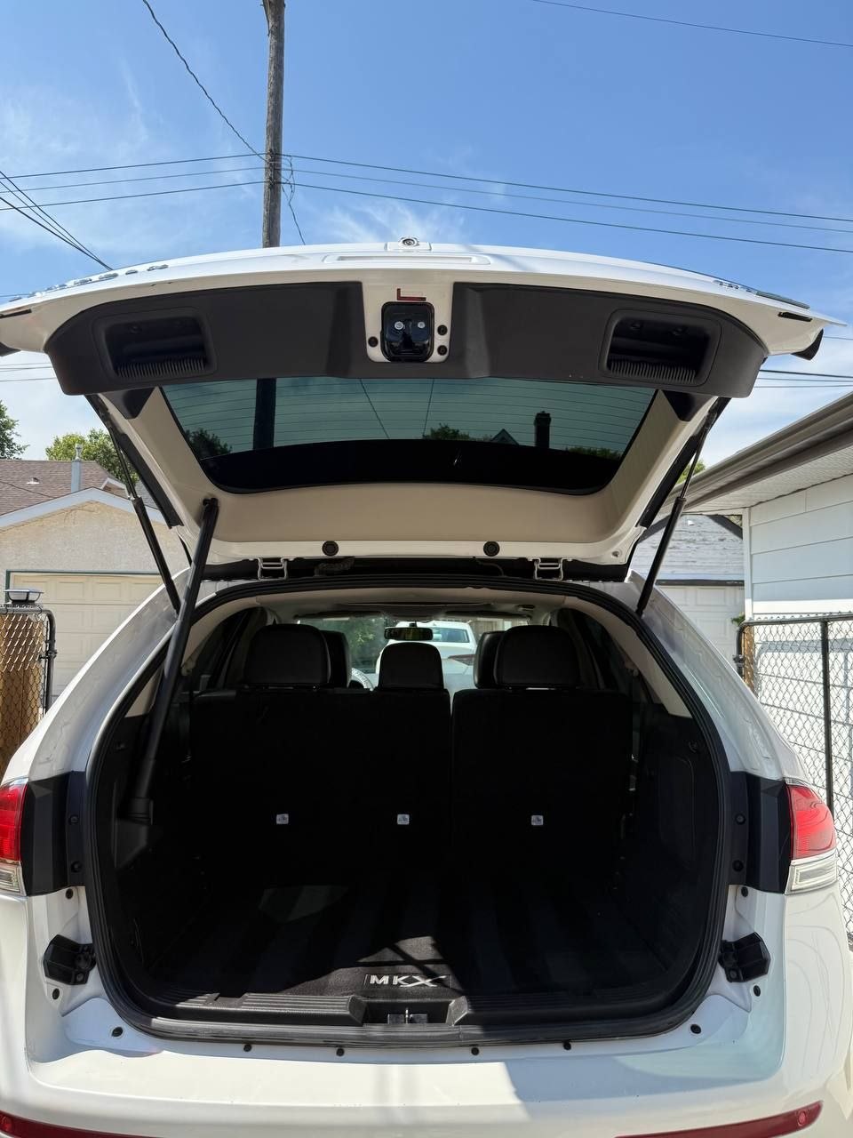The same MKX cargo area after cleaning, tailgate raised, the carpet and sill clear